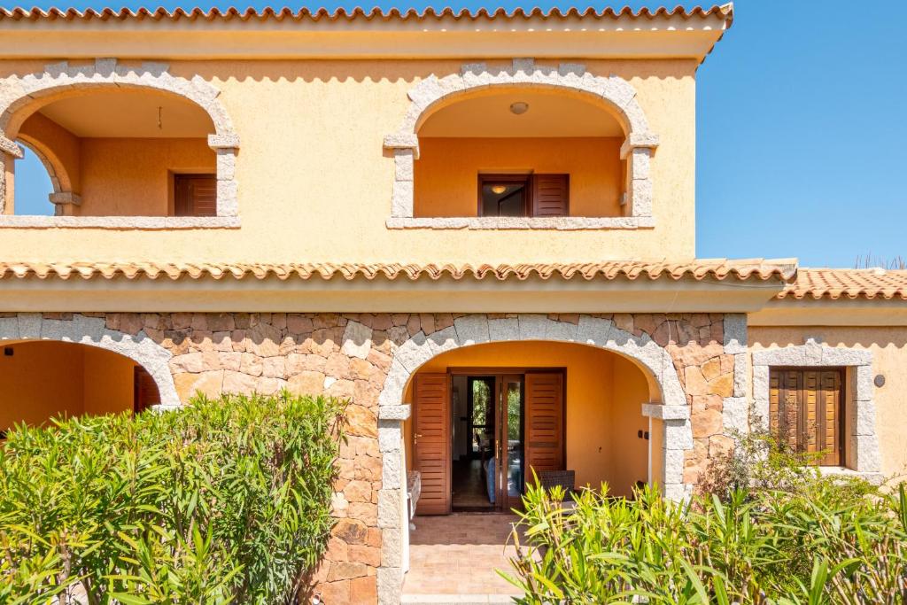 a house with arched windows and a front door at Villetta Confortevole in San Teodoro