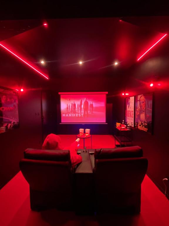 a living room with red lights and a large screen at Suite cinéma et jacuzzi privé in Melun