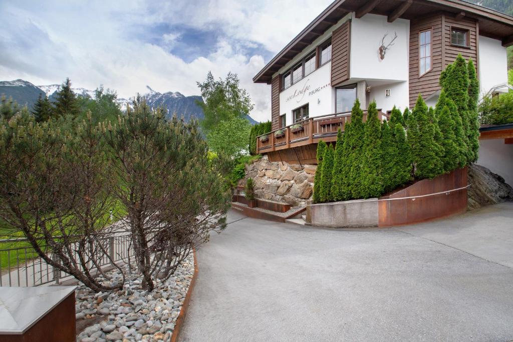 a house with a stone wall next to a driveway at Ferienhaus Plattner in Oetz