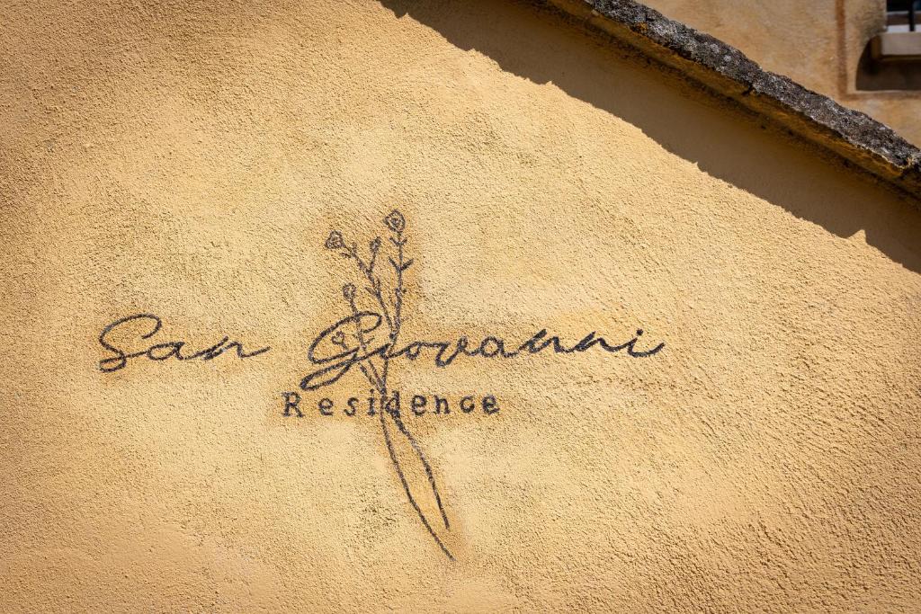 a sign on the side of a building that says san equipment resistance at San Giovanni Residence in Peccioli