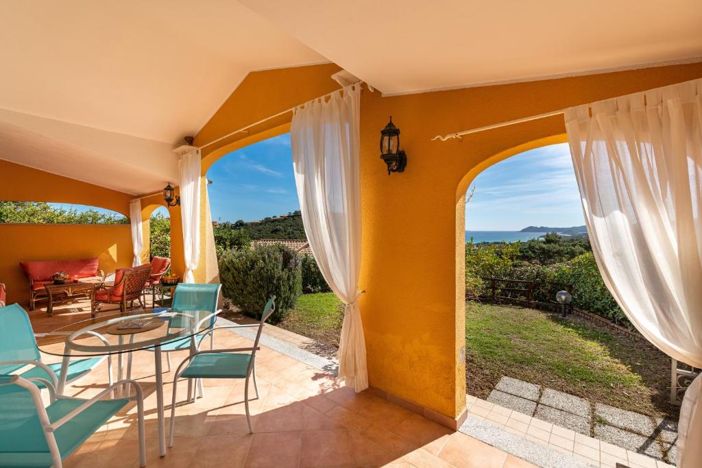 a patio with a table and chairs and a view at Domixedda in Costa Rei