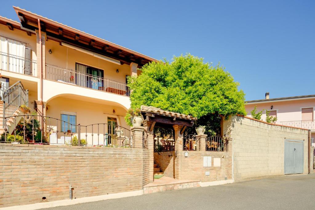 a house with a brick wall and a tree at Casa Rosa in Fluminimaggiore