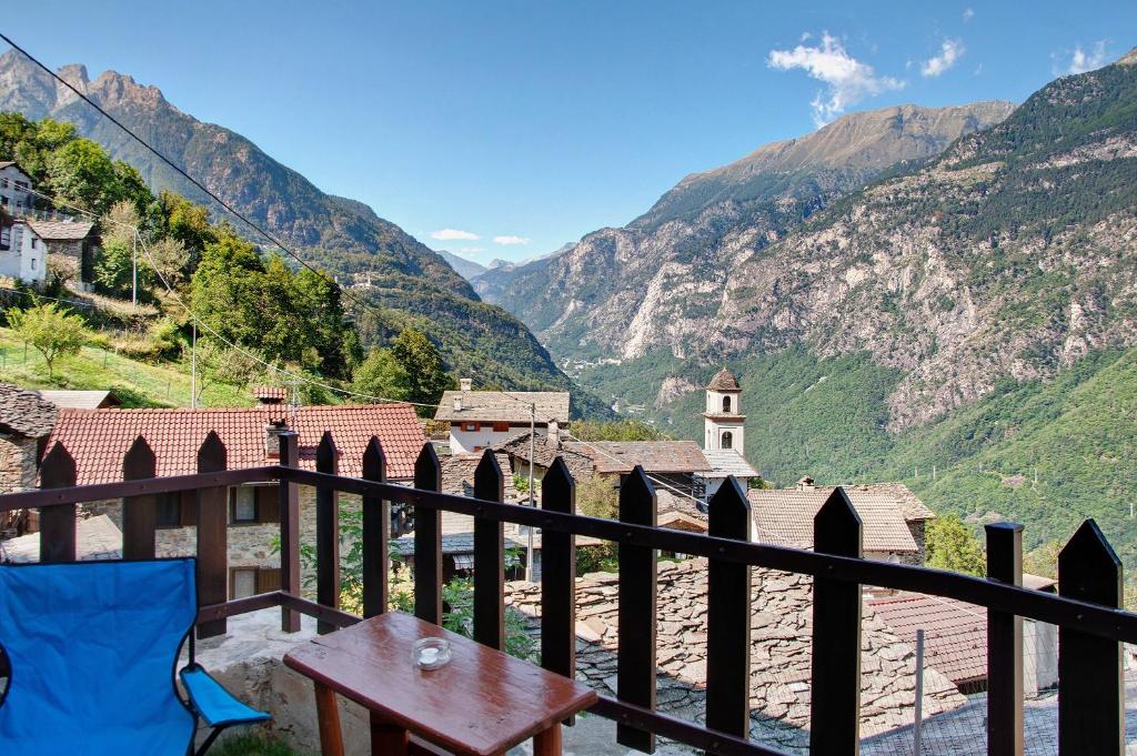 a balcony with a table and a view of a mountain at Sweet Somma Mountain Lodge 1 in San Guglielmo