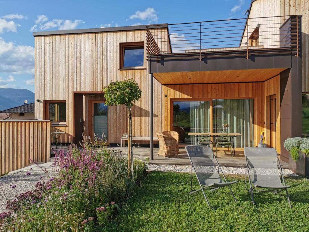 a house with a patio and chairs in the yard at Landhaus Silene in Sarnonico