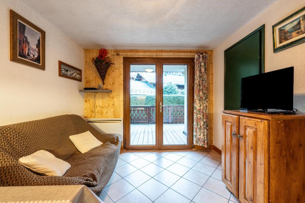 a living room with a couch and a flat screen tv at Appartement Résidence Ours Blanc in Les Houches