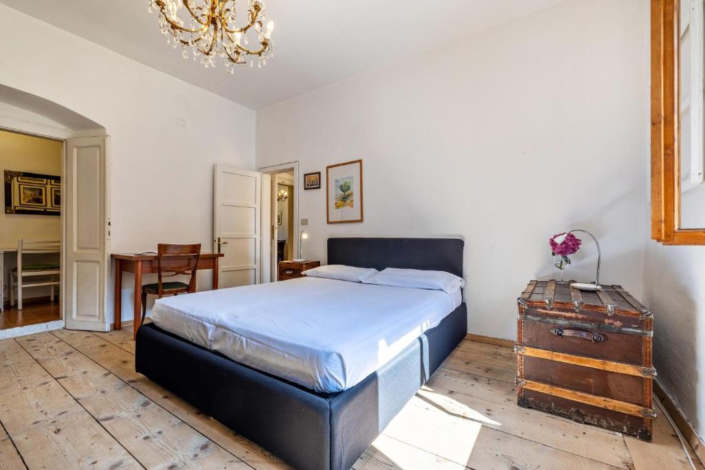 a bedroom with a bed and a desk and a table at Casa nel Borgo Iris in Breguzzo