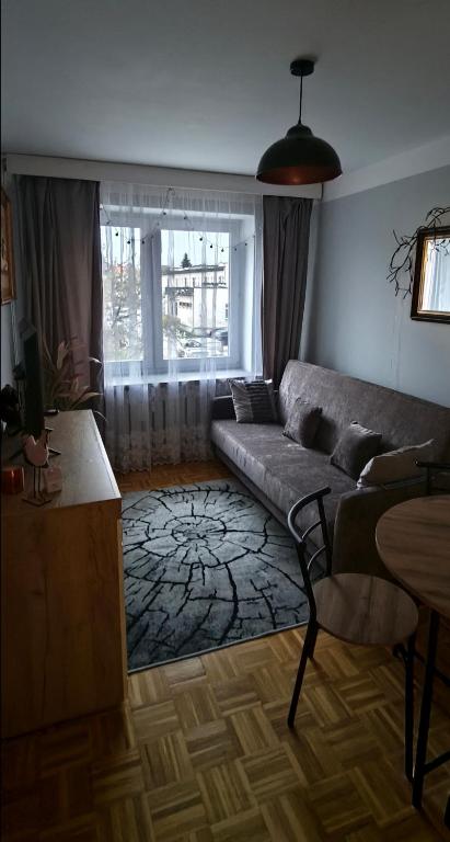 a living room with a couch and a table at Przytulne mieszkanie Szopena in Jasło