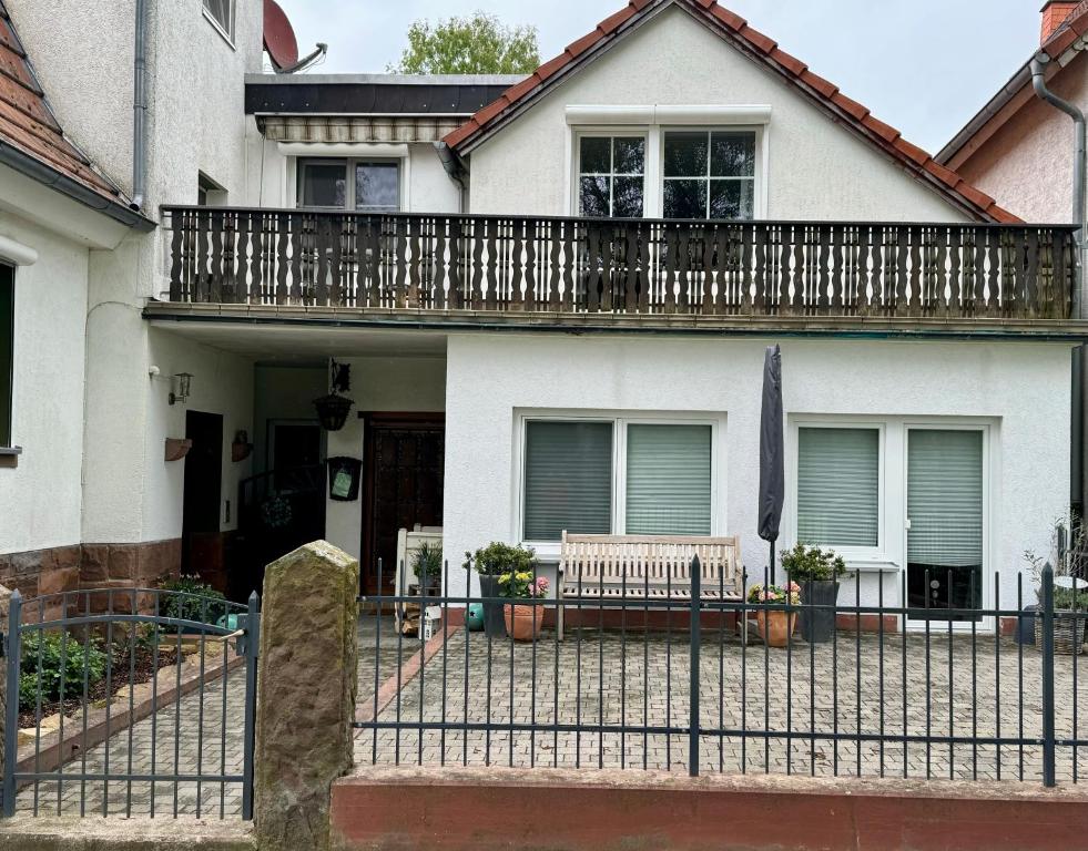 a white house with a fence and a bench at Ferienwohnung Fuldawiesen in Schlitz
