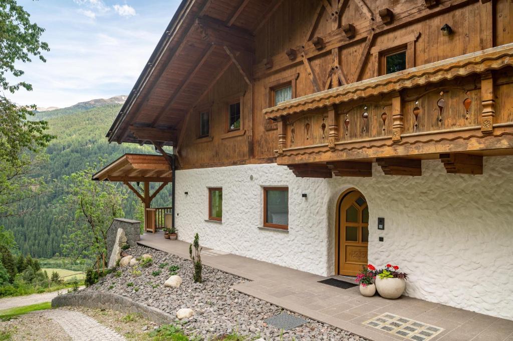 a large building with a wooden roof and a door at Eggerhof im Sarntal in Sarntal