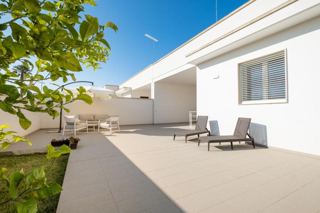 a patio with chairs and tables on a white building at La Tavernetta di Elisa in Calimera