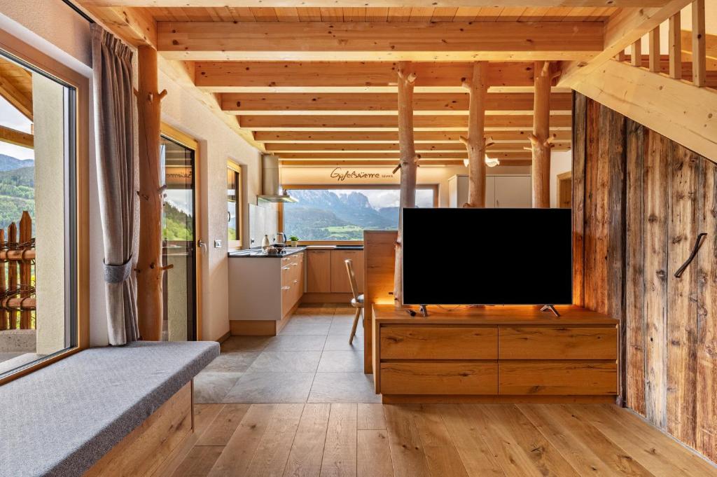 a living room with a flat screen tv on a wooden cabinet at Weirerhof Lebm Gspiarn in Barbiano