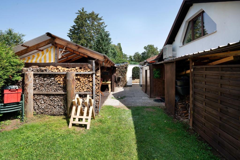a group of wooden buildings with a gate and grass at Appartment Antilope im Würmtal in Gräfelfing