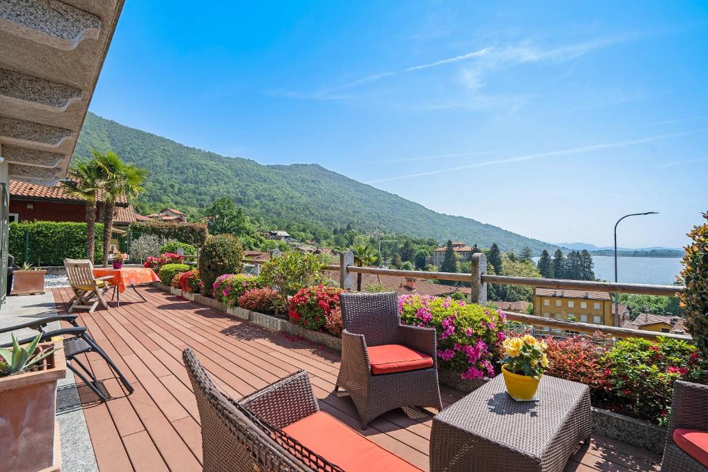 a patio with chairs and tables and flowers on a balcony at Casa Marina in Mergozzo