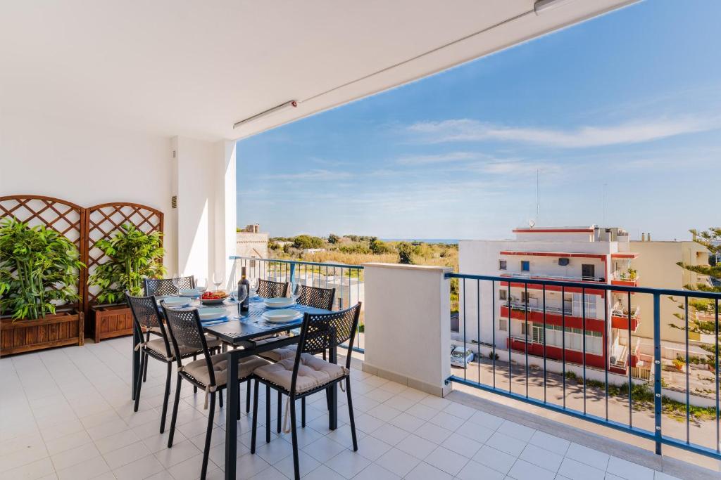 a dining room with a table and chairs on a balcony at Dimora di Artemide in Otranto