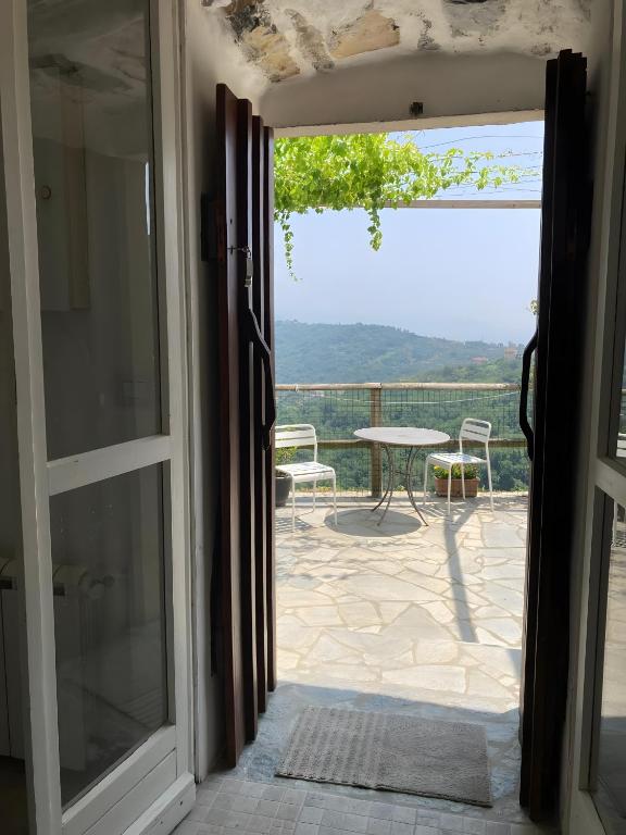 an open door to a patio with a table and chairs at Fattorialmare Rossa in Camogli