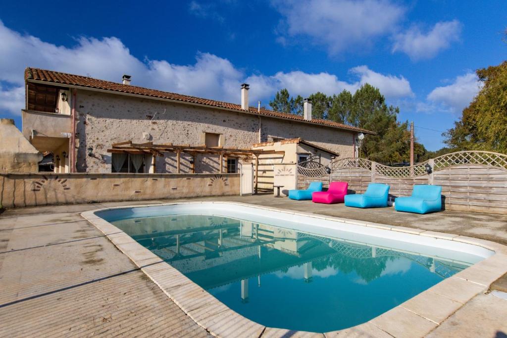 a swimming pool in front of a house at L'Ecurie in Guizengeard