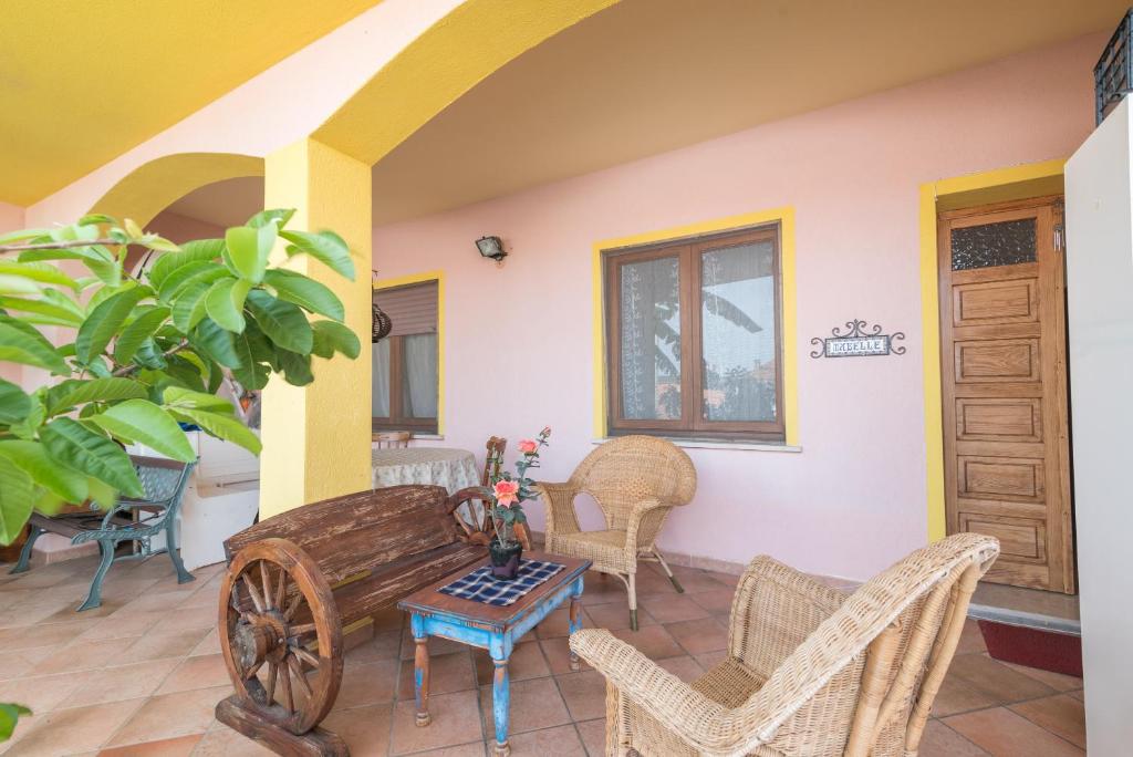 a patio with a wooden bench and chairs and a table at Casa Mabelle in Palau