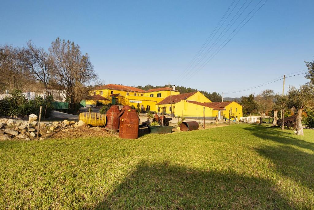 a yard with a yellow house in the background at Df Alojamentos e Suites in Coimbra