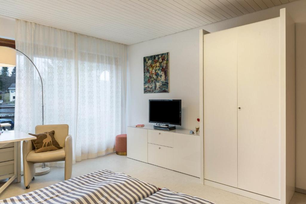 a white room with a desk and a television at Ferienwohnung Nina in Schönwald