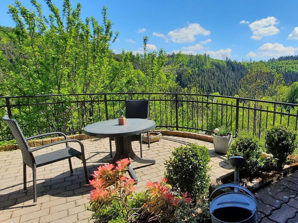 a patio with a table and chairs on a balcony at Ferienwohnung Voege am Waldrand in Schmallenberg