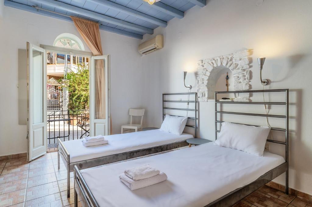 two beds in a room with a balcony at En Tino 1 in Tinos