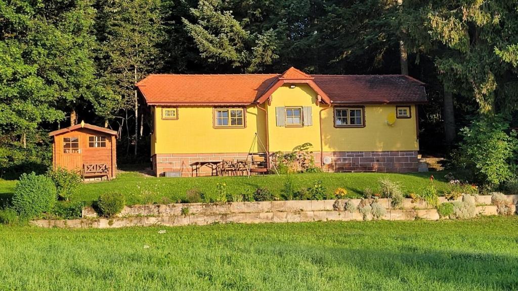 a yellow house sitting in the middle of a field at Bienenhaus in Dornhan