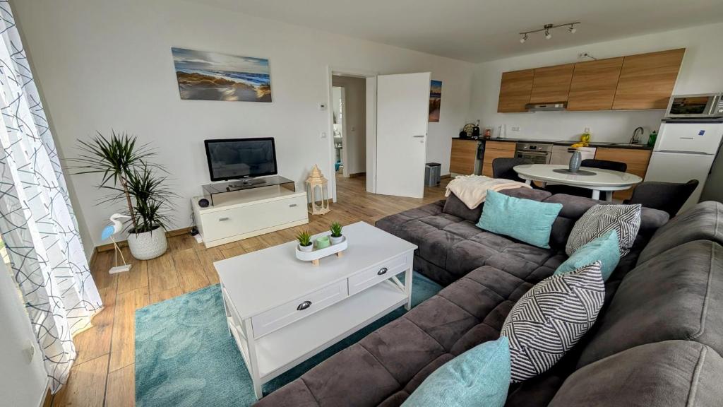 a living room with a couch and a tv at Ferienwohnung Strandliebe in Lubmin