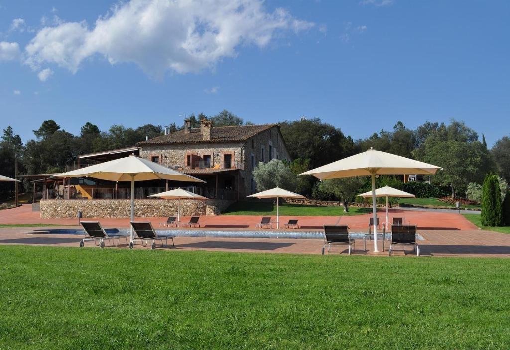 a group of chairs and umbrellas in front of a building at luxury stone villa in Girona