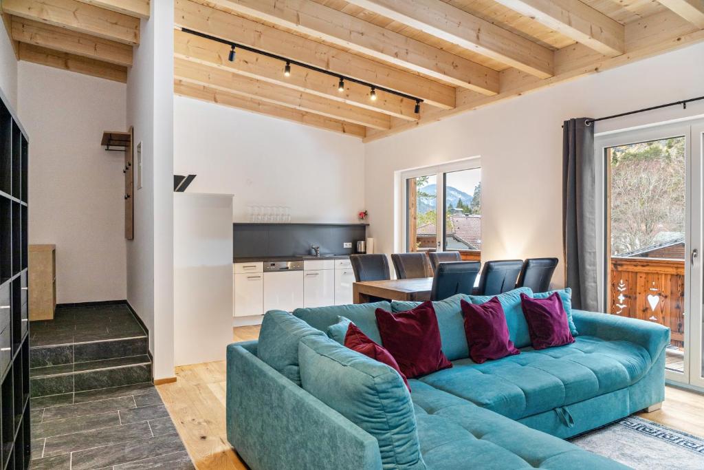 a living room with a blue couch and a kitchen at Apartment Lorenz in Scharnitz