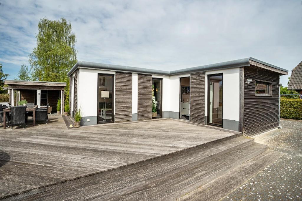 a house with a large wooden deck at Nova Ferienhaus, 50qm in Ueckermünde