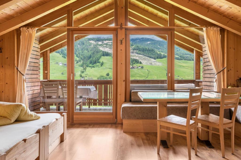 a room with a table and chairs and a large window at Paracia App Pic Pec in Badia