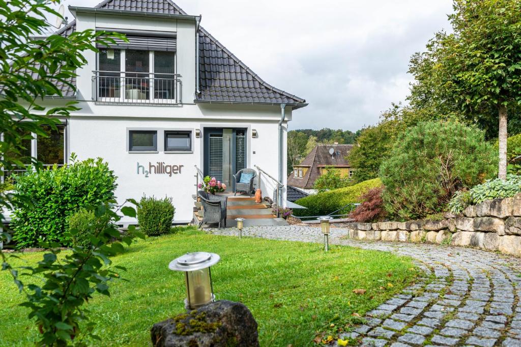 a house with a garden and a stone path at Ferienwohnung Refugium Nest in Sigmaringen