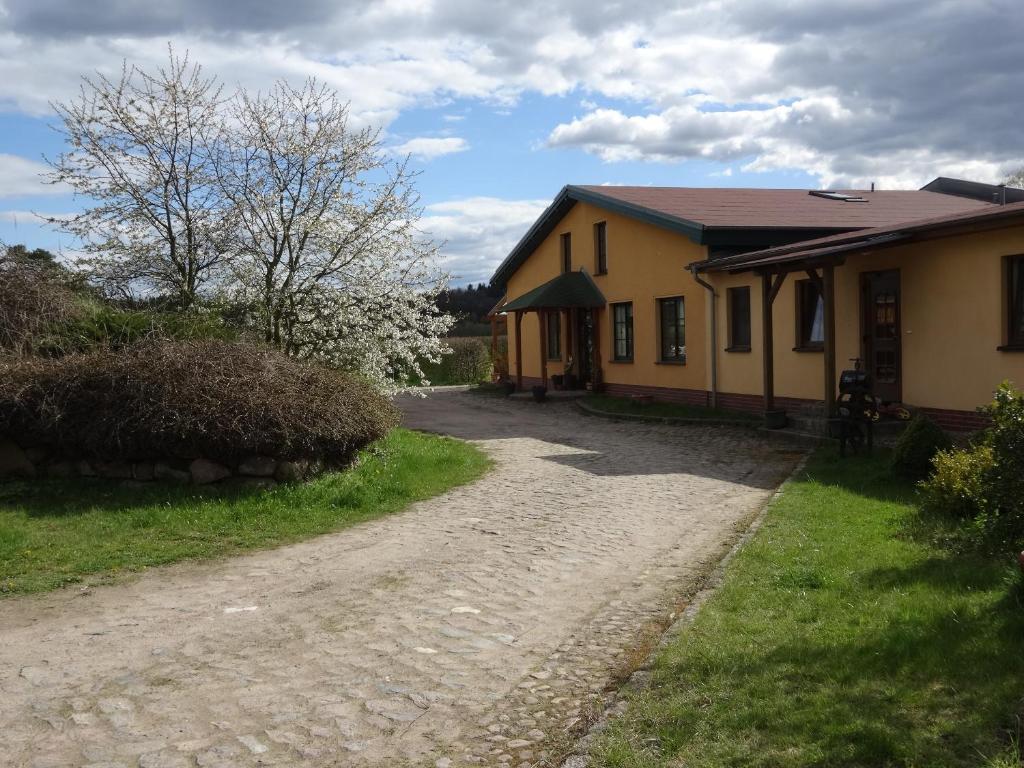 a house with a dirt road in front of it at Ferienbauernhof - Ferienwohnung 6 in Grünow