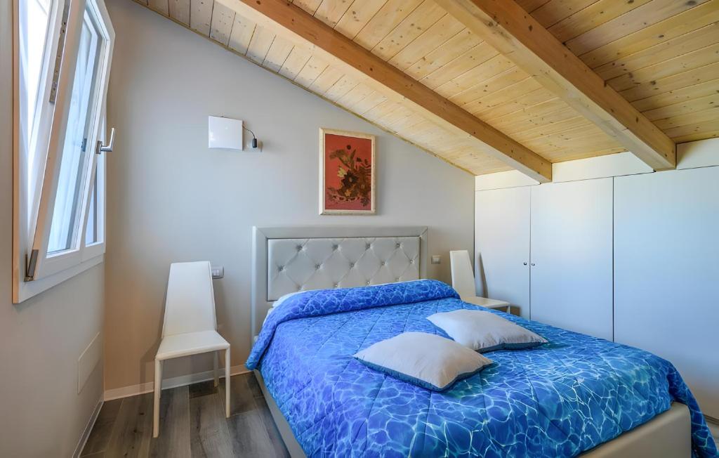 a bedroom with a bed with a blue comforter at Piccolo Chalet Comfort E Stile in Marotta