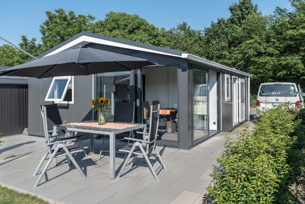 a black shed with a table and chairs and an umbrella at Haus Ferdi in Koblenz