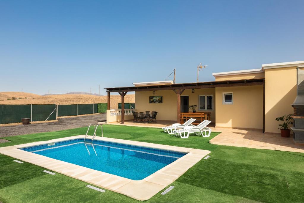 a yard with a swimming pool and a house at Villa Ralue in Tuineje
