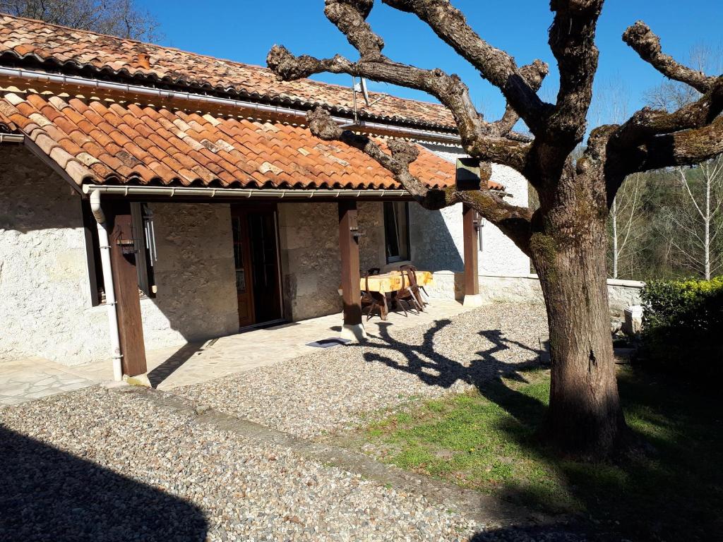 a house with a tree in front of it at Maison De Campagne in Barbaste