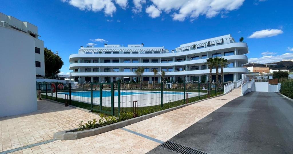 a large building with a swimming pool in front of it at Flat Sun Garden in Torrox