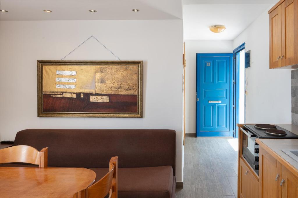a kitchen with a table and a blue door at Calliope Maille Family House in Kalymnos