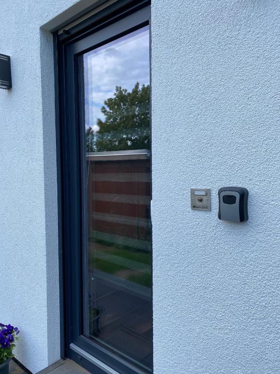 a door with a window next to a house at Zum Kölpiensee in Peenemünde