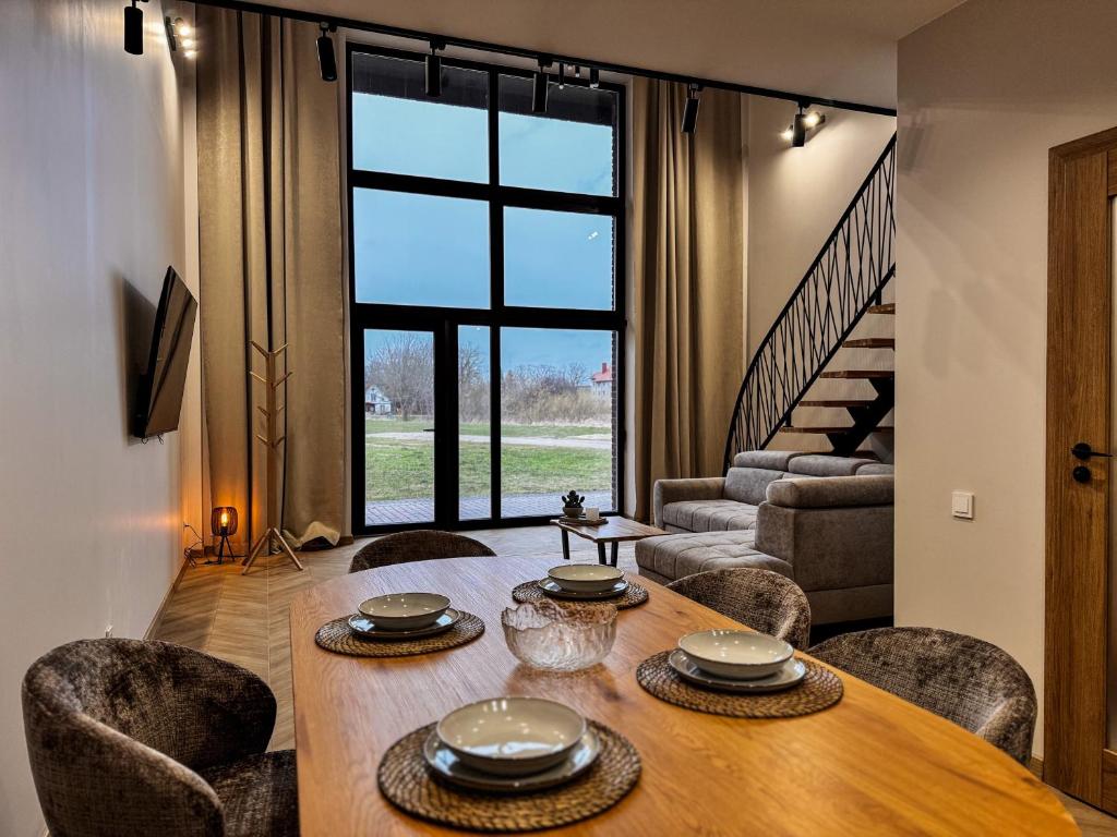 a dining room with a wooden table and chairs at Amber loft 12 Rusnė in Rusnė
