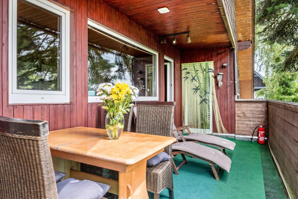 a patio with a wooden table and chairs at Ferienwohnung Klee in Fedderwarden