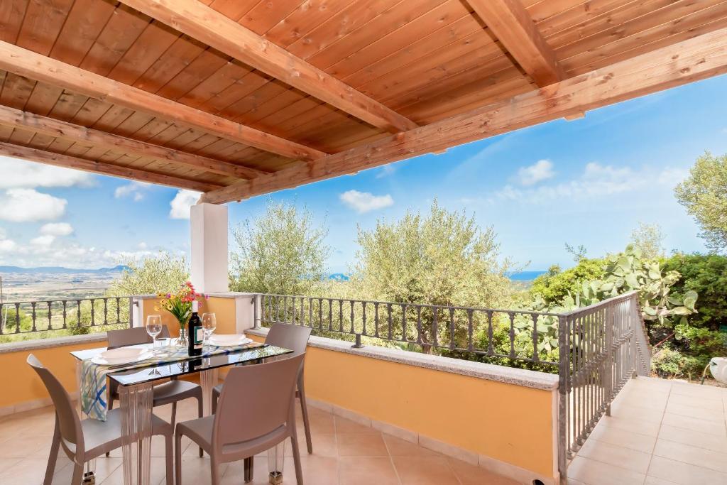eine Terrasse mit Tisch und Stühlen auf einem Balkon in der Unterkunft Casa Angus in Badesi