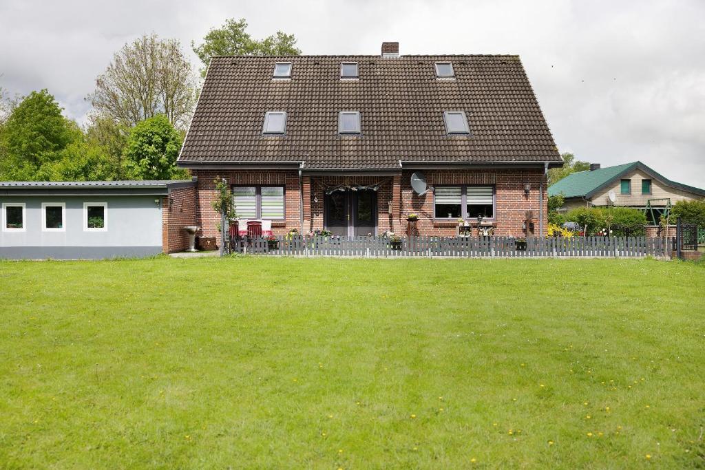 a house with a grass yard in front of it at Ferienwohnung Kudensee in Kudensee