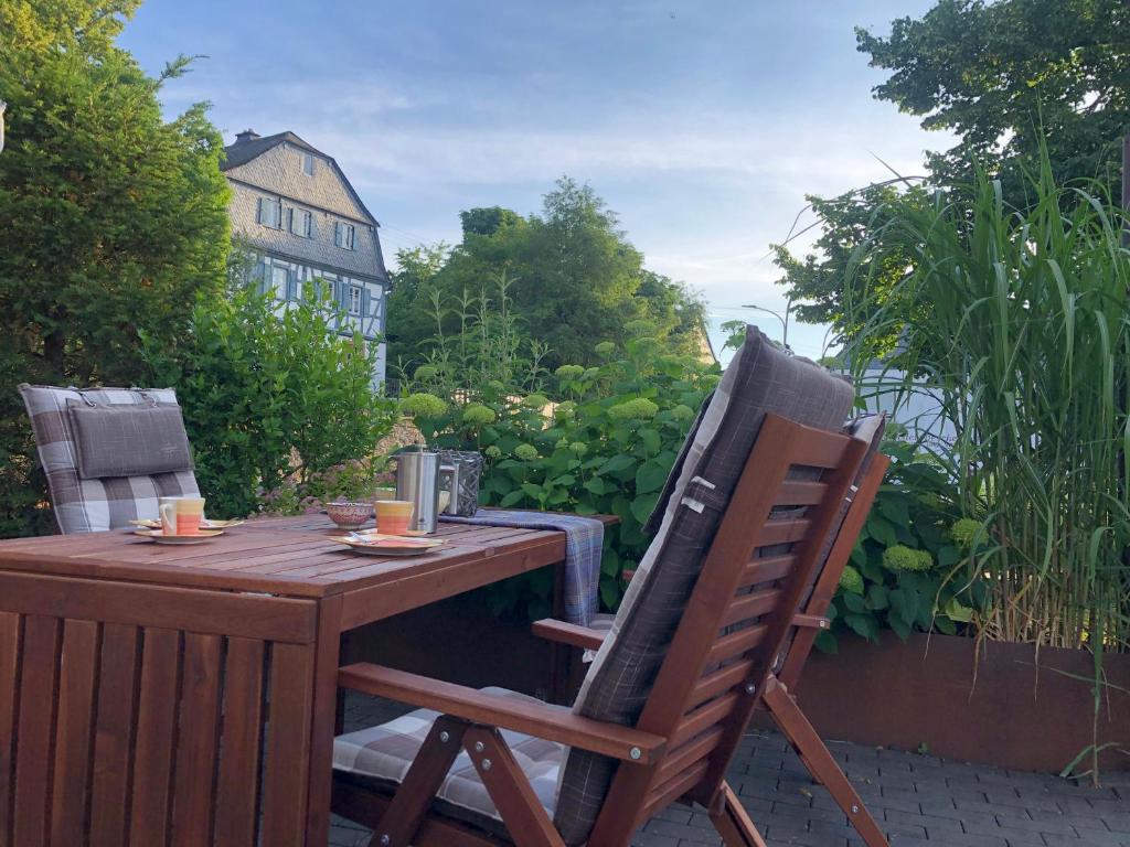 a wooden table and two chairs on a patio at Waldmomente in Schauren