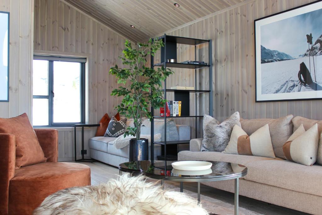 a living room with a couch and a table at Beitostølens smørblomst in Beitostøl