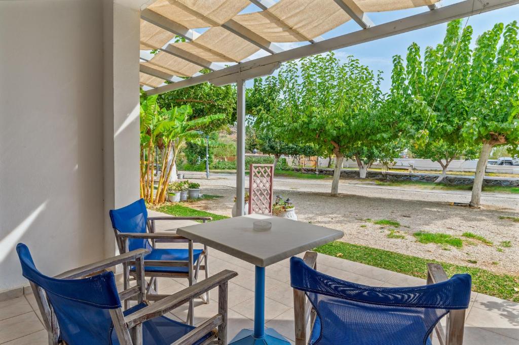 a table and chairs on a patio with a pergola at Perasma Studios 9 in Kipri
