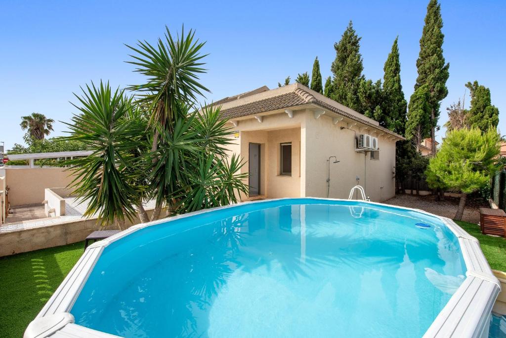 a large blue swimming pool in front of a house at La Terraza in Riumar