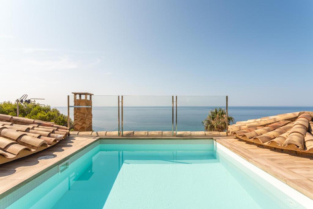 a swimming pool with a view of the ocean at Villa con Infinity pool in Lloret de Mar
