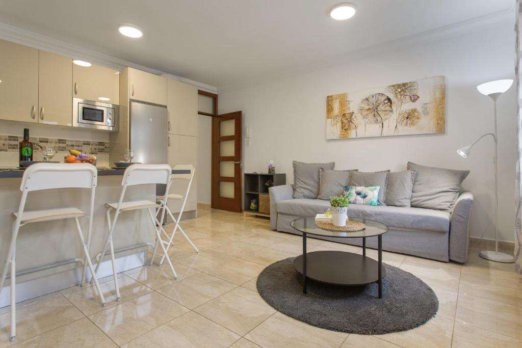 a living room with a couch and a table and a kitchen at Apartamento Rolycar 204 in Icod de los Vinos